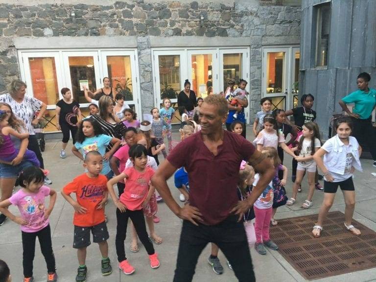 Children dancing outside during performing arts workshop.