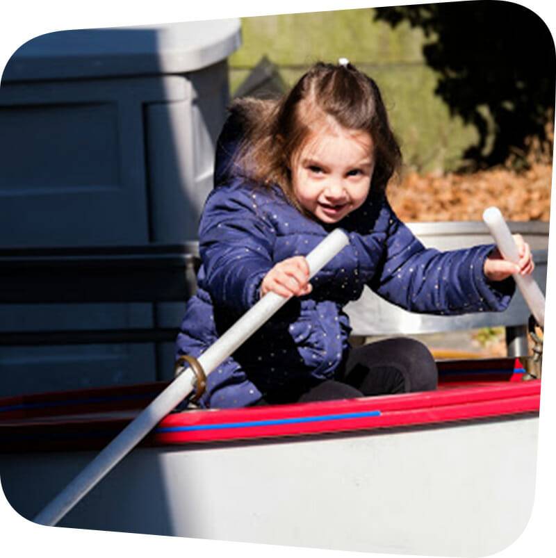 child playing in sea of boats