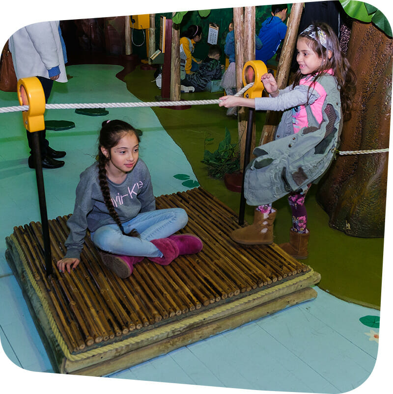 child pulling raft across river in Great Explorations exhibit