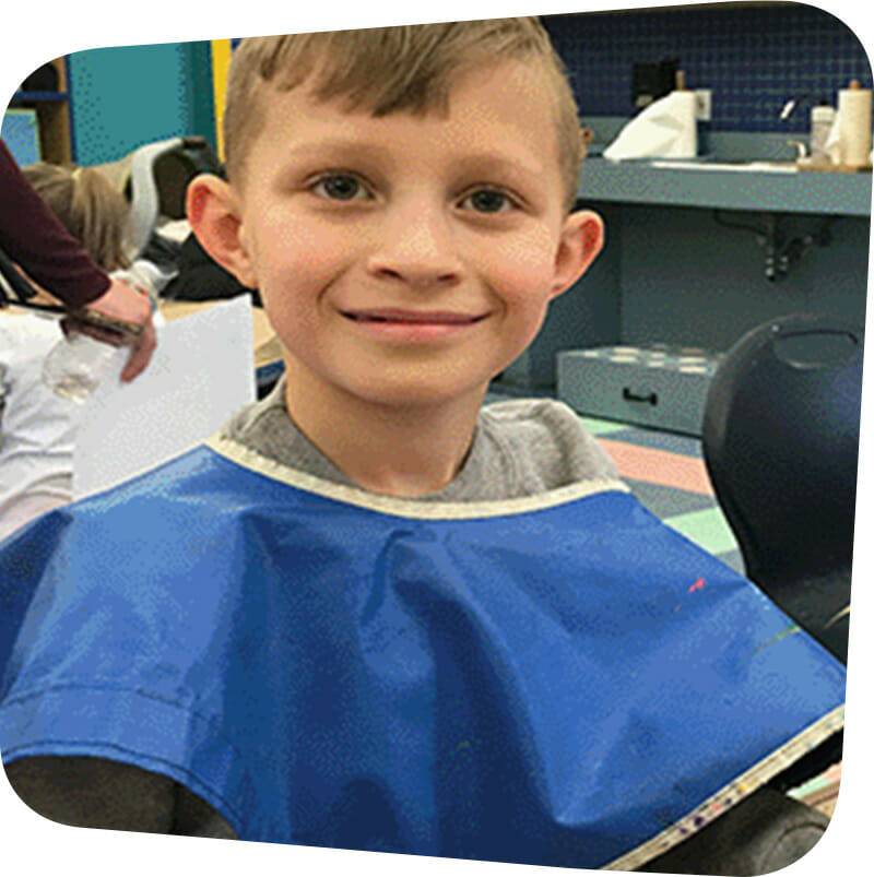 Child smiling while making arts and crafts.