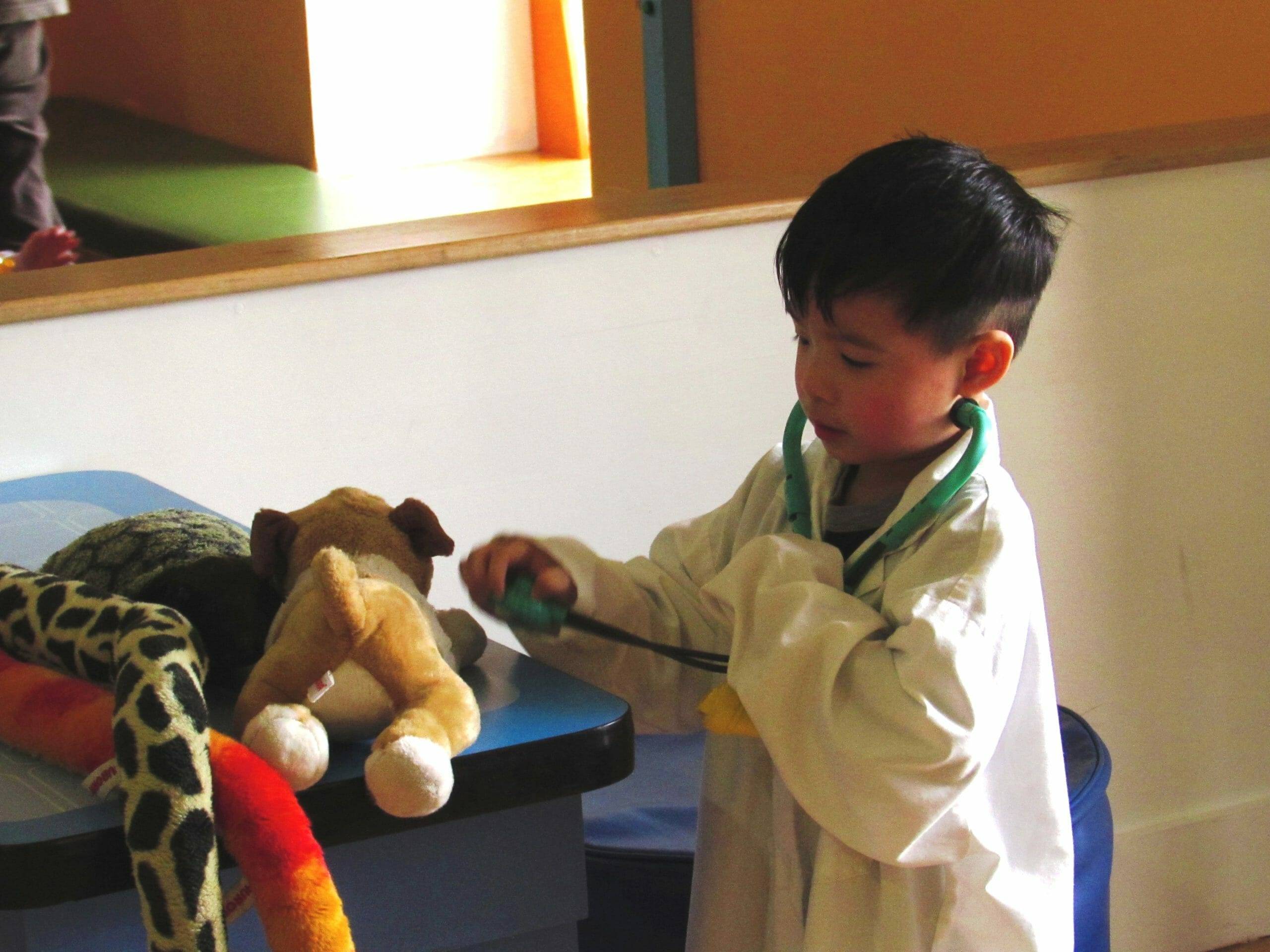 child wearing white doctors coat in vet's office.