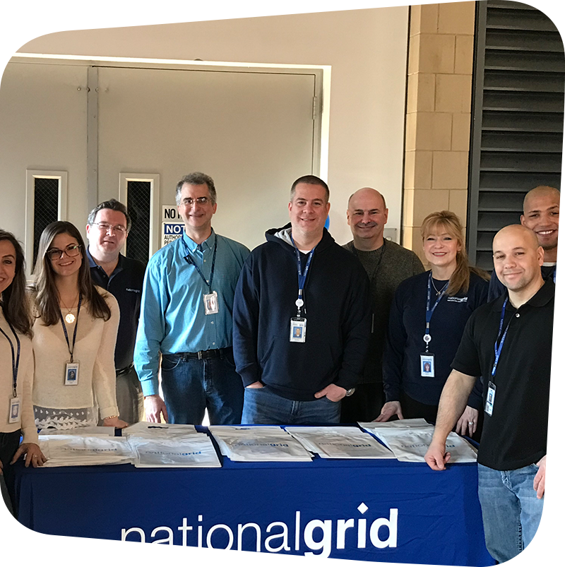 national grid team posing in front of national grid table.
