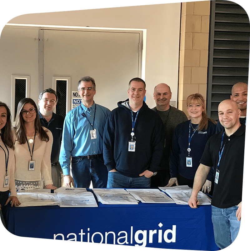SICM_0000_Corporate-Giving national grid team posing in front of national grid table.