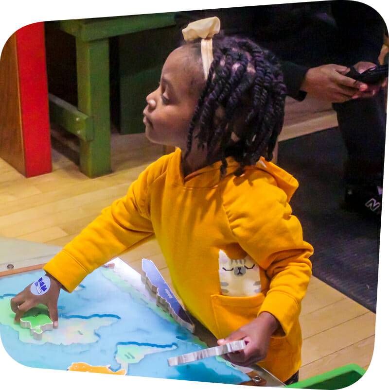 child playing with map in Great Explorations exhibit