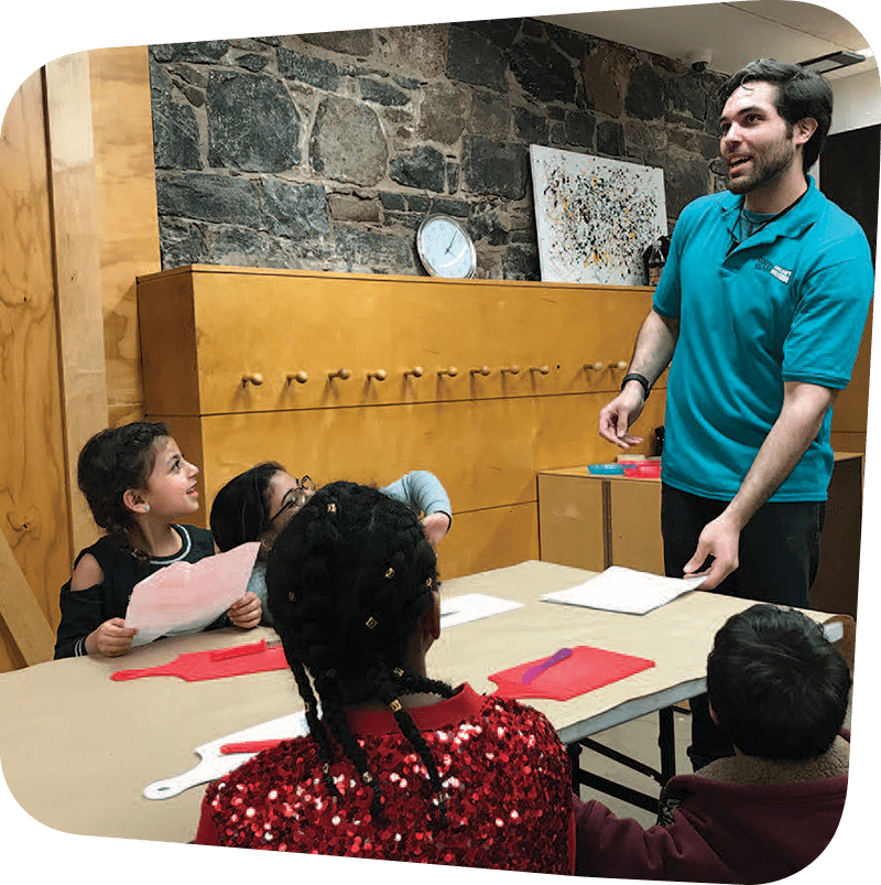 Children looking up and learning from museum staff.