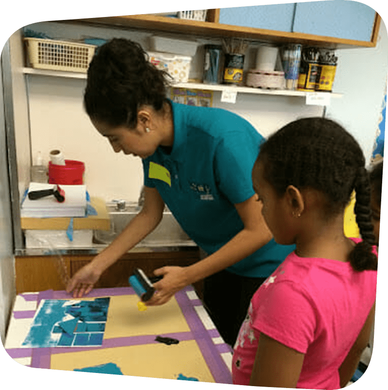 child and staff working on artwork