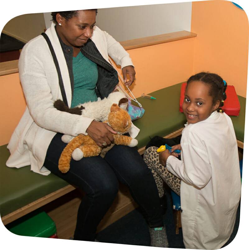 child and adult playing in vet's office