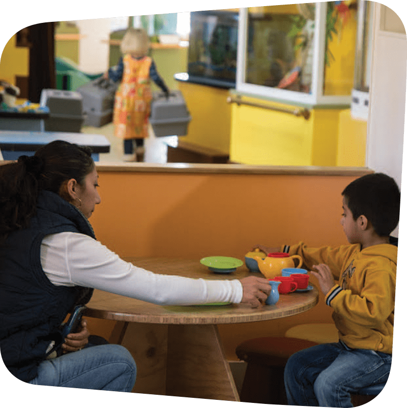 Child and adult playing with utensils.