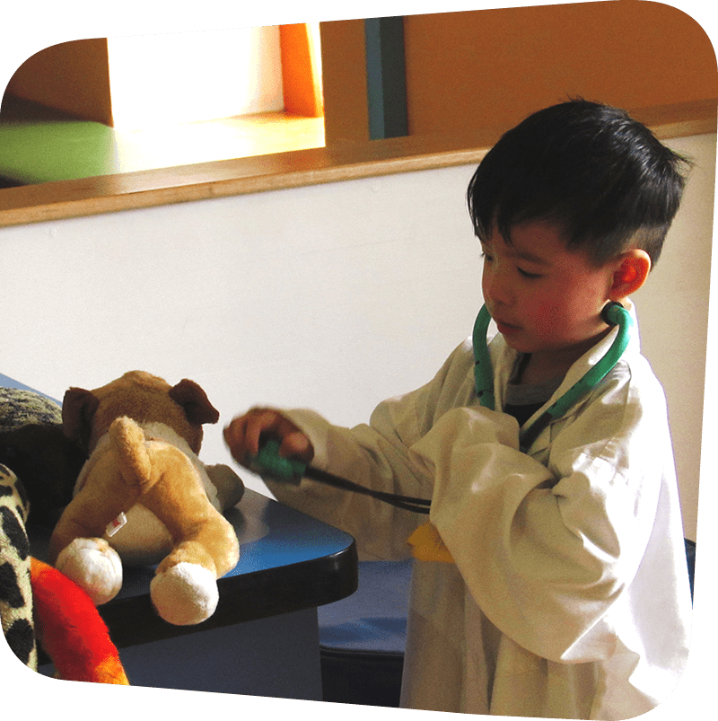 SICM_0003_Vet27s-Office child wearing white doctor coat playing in vet's office