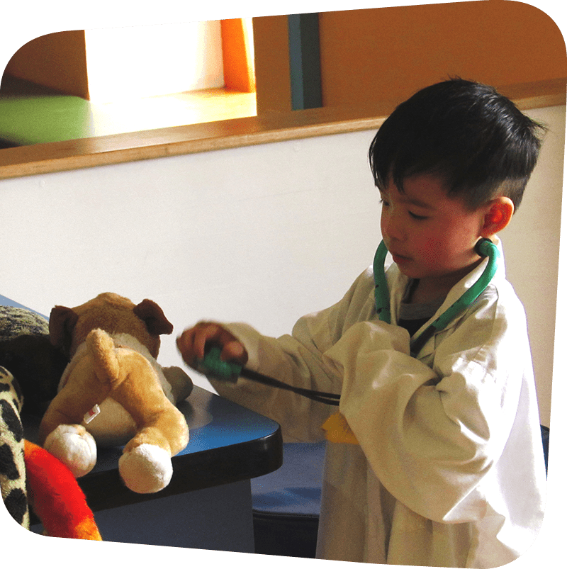 child wearing white doctor coat playing in vet's office