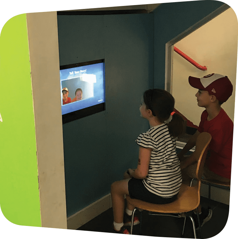 SICM_0005_I-Am-Going-to-the-Staten-Island-Children27s-Museum21-Visitors27-Guide-Oct-2018_Page_06_Image_0001 two children smiling at screen of themselves