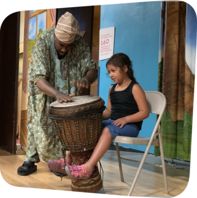 child seated while man plays drums