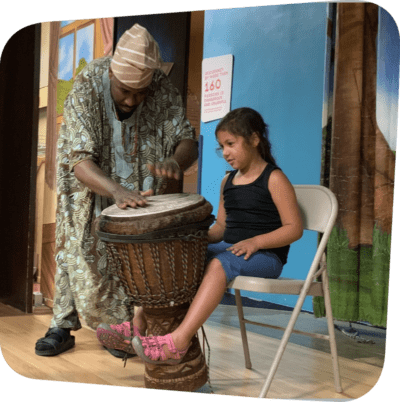 child seated while man plays drums