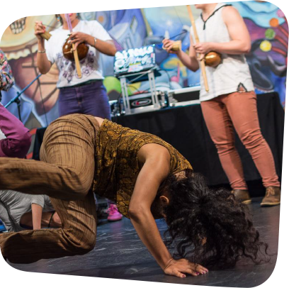 capoeira dancer dancing and people clapping in a circle