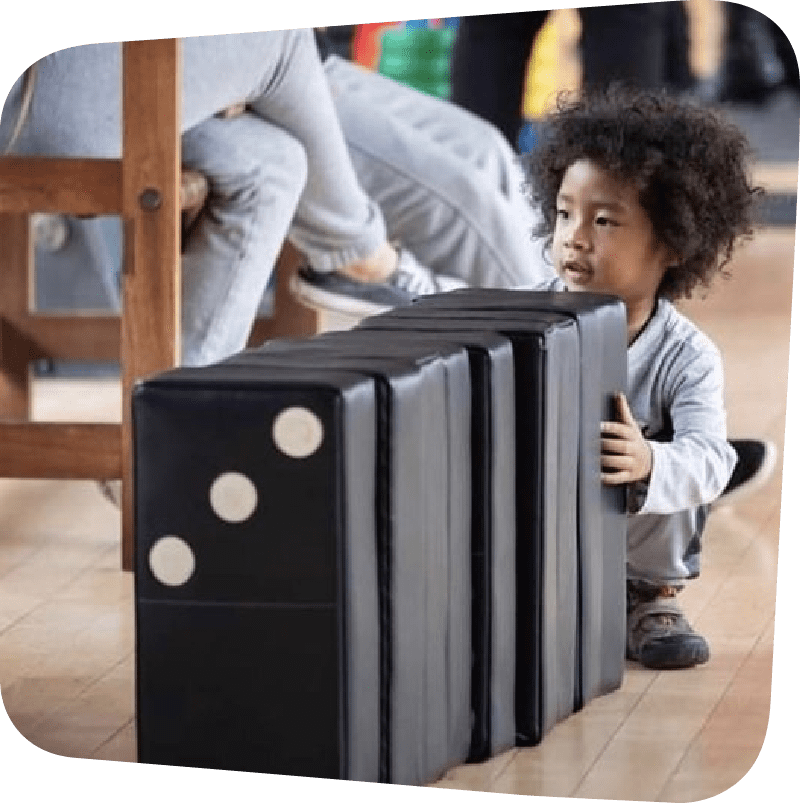 child playing with dominoes in big games