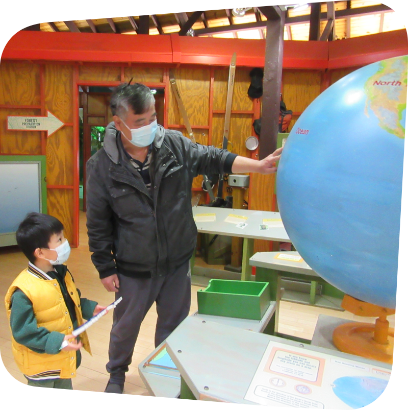 parent and child looking at globe in great explorations