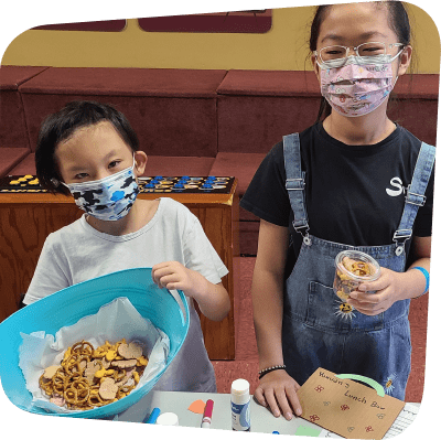 two children displaying snacks they have made