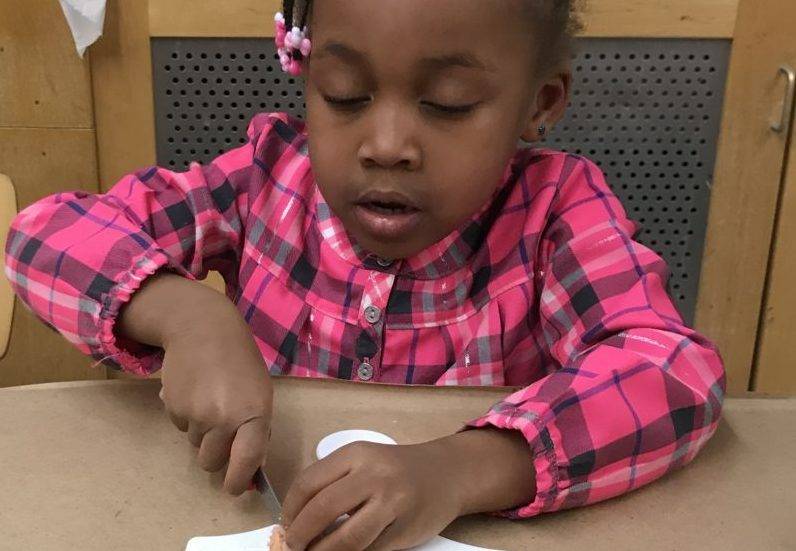 toddler cutting on cutting board