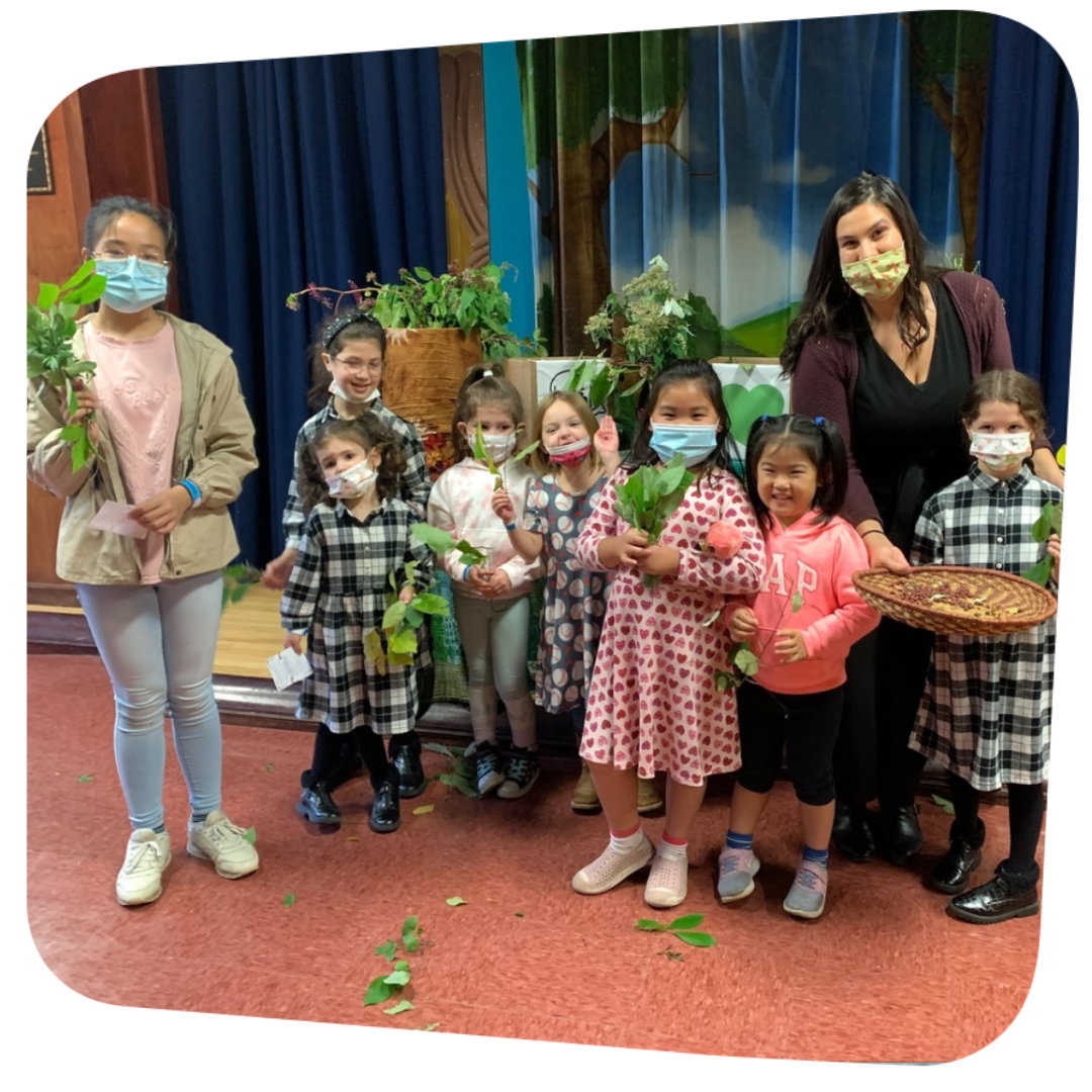 Glam Gardner with a group of children holding plants and smiling for the camera