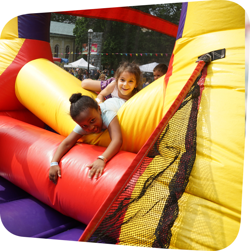 childrens laughing as they tumble out of a bounce house