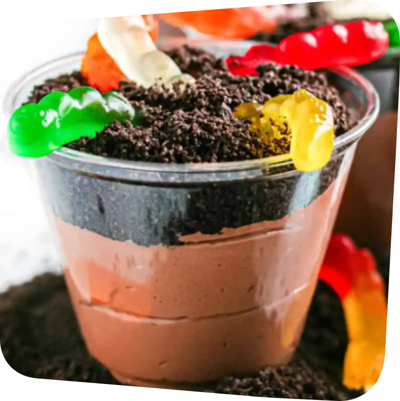 cup filled with pudding and topped with cookie crumbs and gummy worms