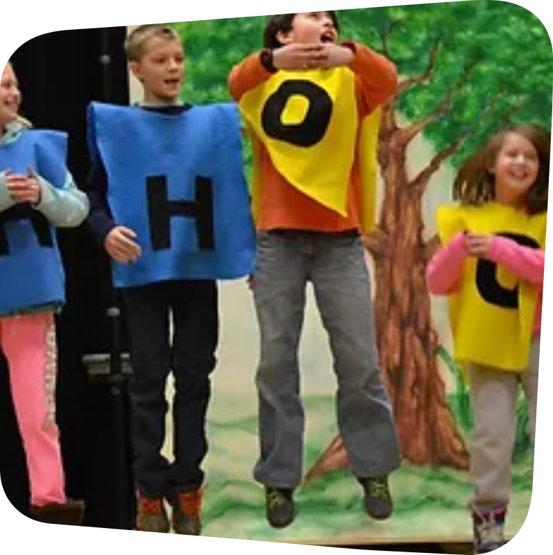 children in blue and yellow ponchos with letter H or O on them jumping up and down