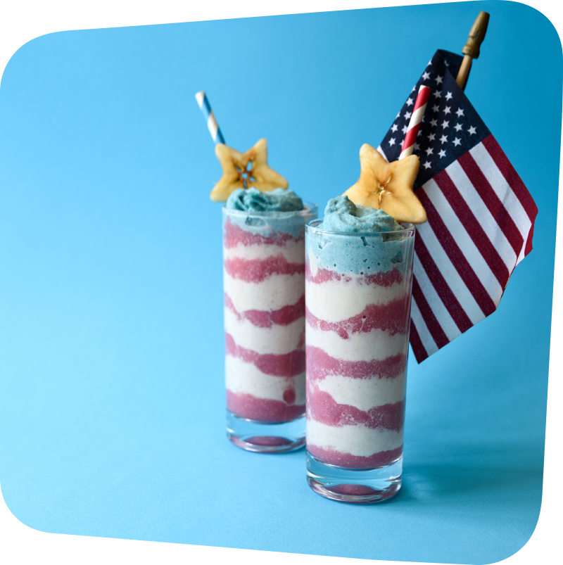 two tall glasses with smoothie layered red, white and blue