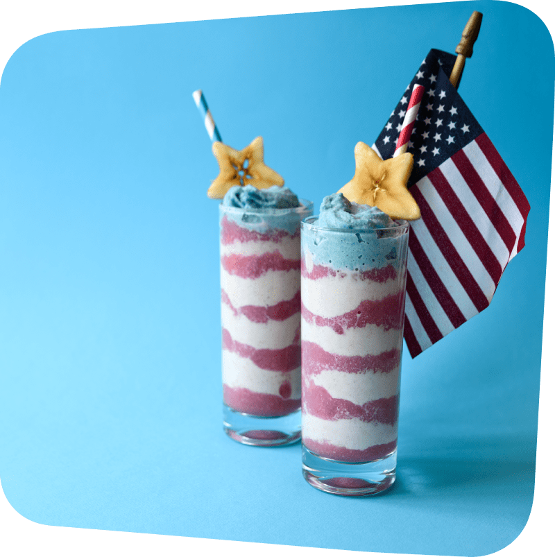 two tall glasses with smoothie layered red, white and blue