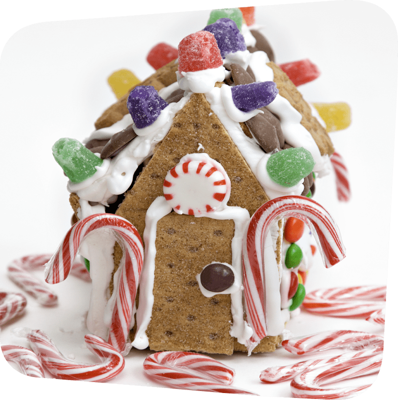 House made out of graham crackers with white icing and candy decor