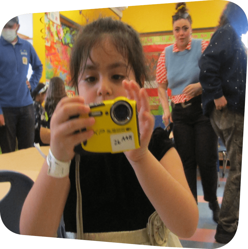 a child practicing using a camera in our portraiture workshop