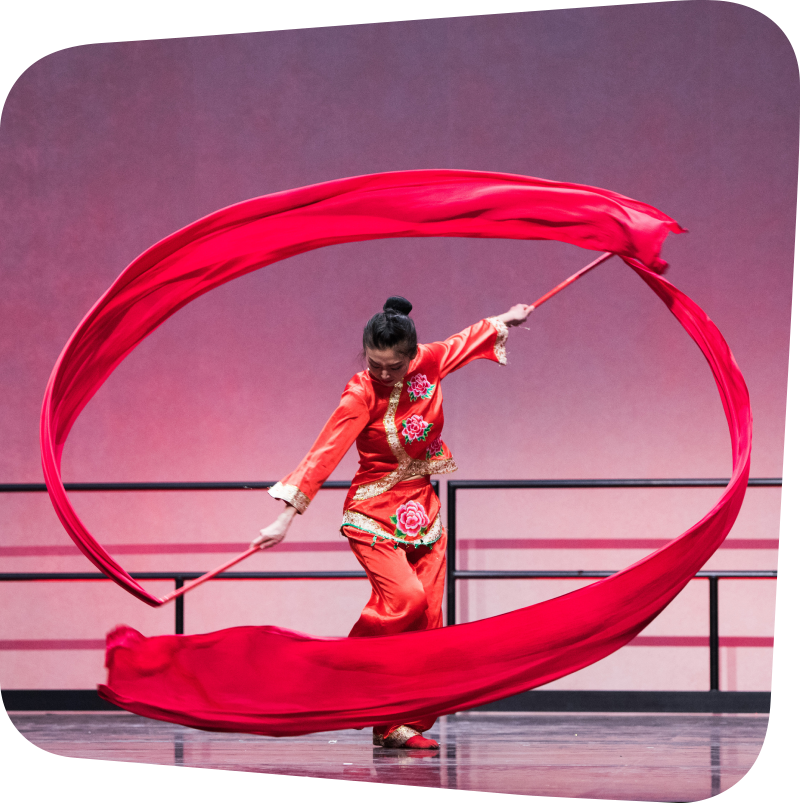 Woman in red preforming dual ribbon dance