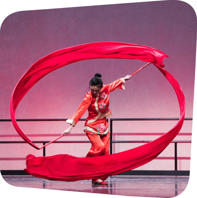Woman in red preforming dual ribbon dance