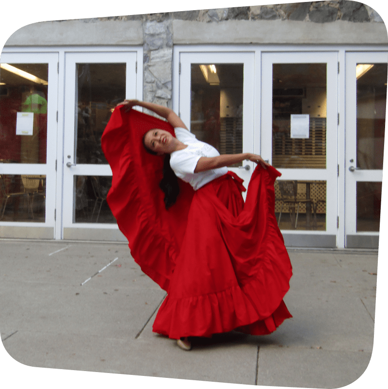 woman in flowing red dress enthusiastically preforming a dance