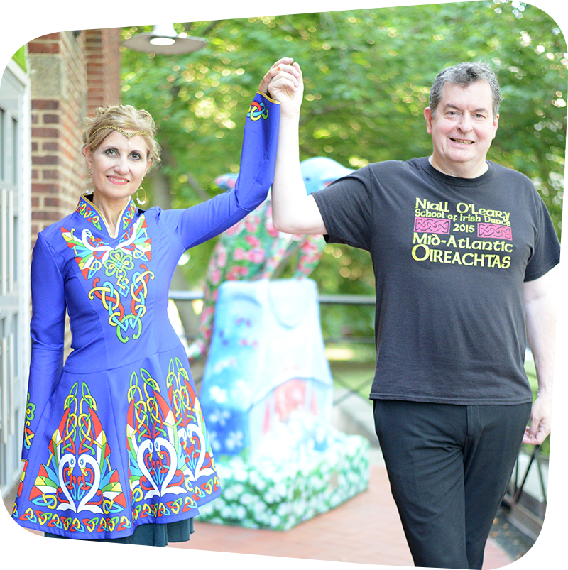 Dawn Daniels in traditional Irish dress and Niall O'Leary holding hands upright