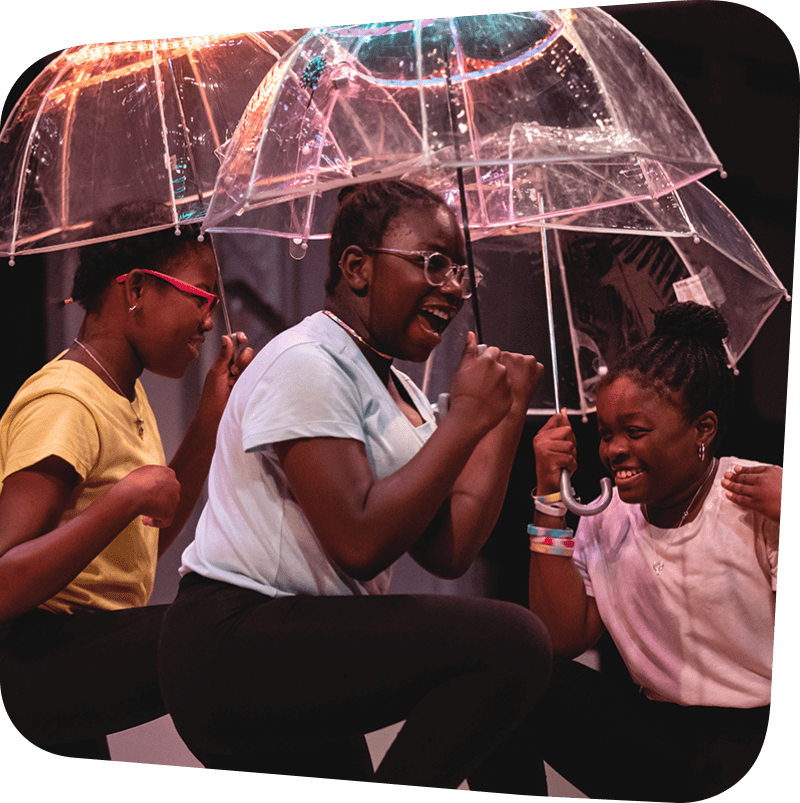 three laughing children featured holding clear umbrellas over their heads