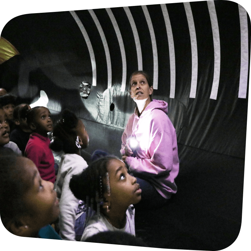 children and a teacher sitting inside an inflatable whale