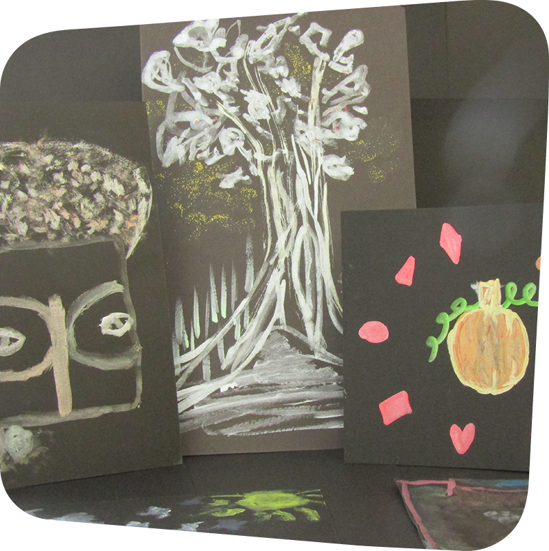 Paintings of an African mask, a tree and a pumpkin made from metallic paints on black paper